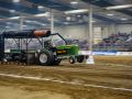 indoor tractor pulling event featuring a green tractor