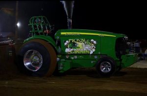 green pulling tractor outside in the evening