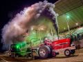 red tractor blowing smoke at tractor pulling event