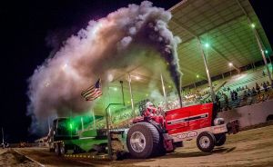 red tractor blowing smoke at tractor pulling event