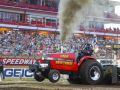 red tractor pulling in front of a crowd of people