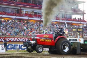 red tractor pulling in front of a crowd of people