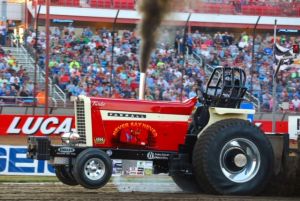 red tractor at a tractor pulling event in front of a bunch of people