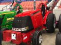 Red shiny pulling tractor parked inside