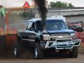 black pulling truck blowing black smoke at truck pulling event