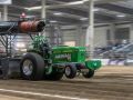 green tractor pulling inside